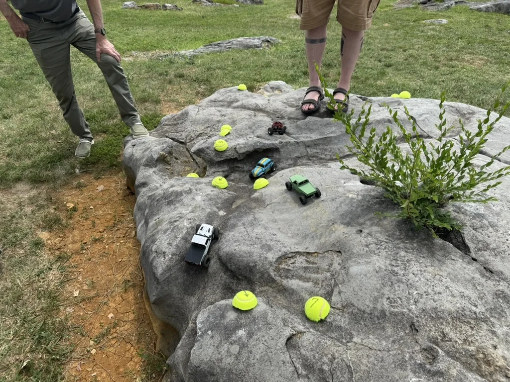RC crawlers competing on a natural rock course